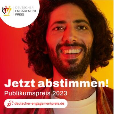 Mann mit dunklen Vollbart und langen Haaren lchelt herzlich in die Kamera. Und forderte mit einem weien Schriftzug die Leser:innen auf fr den Publikumspreis 2023 abzustimmen. 